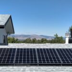 Clean Solar Panels on top of a roof in Colorado with mountains and trees in the background.